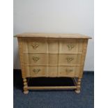 A blonde oak three drawer serpentine fronted chest