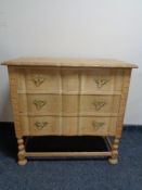 A blonde oak three drawer serpentine fronted chest