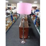 A contemporary metal four-way floor lamp with glass drops and pink shade