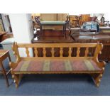 A 20th century oak pew with upholstered cushion