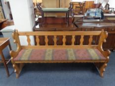 A 20th century oak pew with upholstered cushion