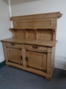 A 20th century blonde oak double door buffet back sideboard in an oriental style with metal mounts