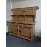 A 20th century blonde oak double door buffet back sideboard in an oriental style with metal mounts