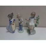 A Lladro figure - Girl seated in tree together with two other Nao figures