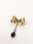 A 9ct gold ribbon shaped bar brooch with garnet drop CONDITION REPORT: 3.