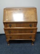 A 1930's walnut bureau fitted with three drawers