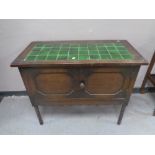 An Edwardian oak double door washstand with tiled top