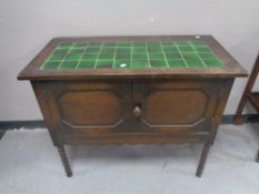 An Edwardian oak double door washstand with tiled top