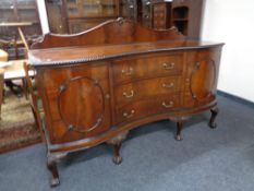 A Victorian mahogany serpentine fronted sideboard on claw and ball feet