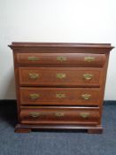 A stained pine four drawer chest with brass drop handles