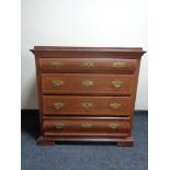 A stained pine four drawer chest with brass drop handles