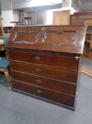 A 19th century oak and mahogany writing bureau fitted four drawers beneath