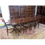 A Regency style twin pedestal extending dining table with two leaves and ten dining chairs