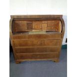 An early 20th century barrel fronted bureau