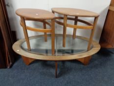 A mid 20th century oval teak coffee table and pair of matching side tables