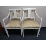 A pair of 20th century white and gilt painted armchairs