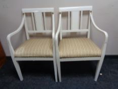 A pair of 20th century white and gilt painted armchairs