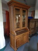 An early 20th century continental oak double door glazed door bookcase fitted cupboards and drawers