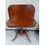 A reproduction mahogany turnover top tea table on four way pedestal