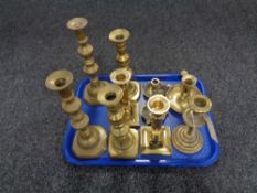 A tray of antique brass candlesticks