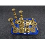 A tray of antique brass candlesticks