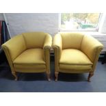 A pair of 20th century tub chairs in mustard fabric on oak legs
