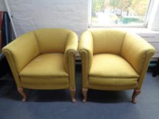 A pair of 20th century tub chairs in mustard fabric on oak legs