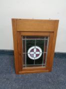 An oak wall cabinet with leaded glass doors