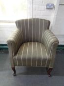 A 20th century low back armchair in striped fabric