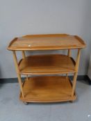 An Ercol elm three tier tea trolley