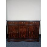 A reproduction mahogany triple door sideboard