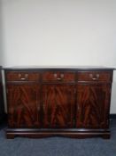 A reproduction mahogany triple door sideboard