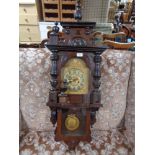 An mahogany wall clock with brass dial