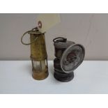 A vintage premiere carbide lamp together with a miniature brass Eccles protector miner's lamp
