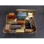 A box of vintage tins, music boxes, anniversary clock under shade,