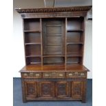 A period style heavily carved oak dresser with brass drop handles