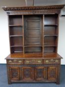 A period style heavily carved oak dresser with brass drop handles