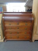 A late 19th century oak barrel fronted bureau