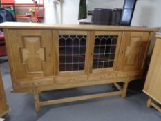 A blond oak sideboard fitted four cupboards and drawers