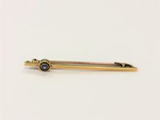 A 15ct gold bar brooch set with a blue gem stone CONDITION REPORT: 2.