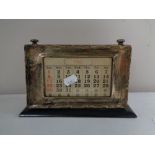 An Edwardian silver fronted scrolling desk calendar