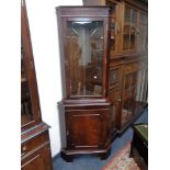 A reproduction mahogany glazed door corner cabinet