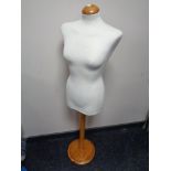 A dress makers mannequin on pine stand