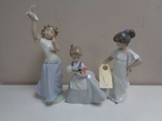 Three Nao figures - Girl with flowers no. 0495, girl in night dress no. 1110 and girl with dove.