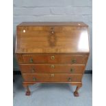 A walnut 1930's bureau on claw and ball feet