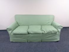 An Edwardian horse hair filled two seater settee with green loose covers