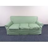 An Edwardian horse hair filled two seater settee with green loose covers