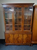 An inlaid mahogany Regency style triple door bookcase