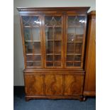 An inlaid mahogany Regency style triple door bookcase