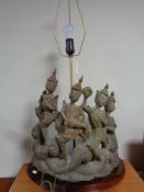 A carved oriental style figural table lamp